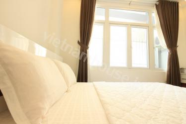 Bedroom with big windows in serviced apartment near Street of Foreigners, District 1