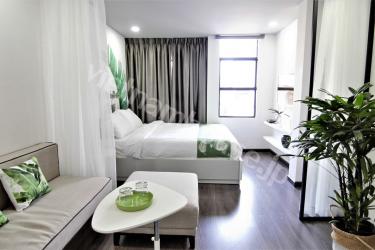 Two white beds within white serviced apartment 